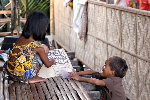 BADJAO EDUCATION. A Badjao girl plays the role of a teacher with her neighbor along the stilt pathway of their home in an area known as Dapsa in Davao City on Monday, 11 August 2014. MindaNews photo by Erwin Mascarinas